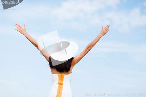 Image of girl with hands up on the beach