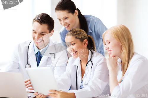 Image of group of doctors looking at tablet pc