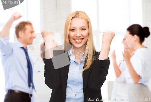 Image of businesswoman celebrating succes in office