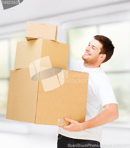 Image of young man carrying carton boxes