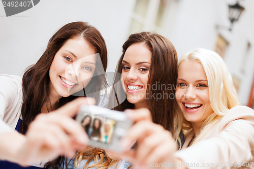 Image of beautiful girls taking picture in the city