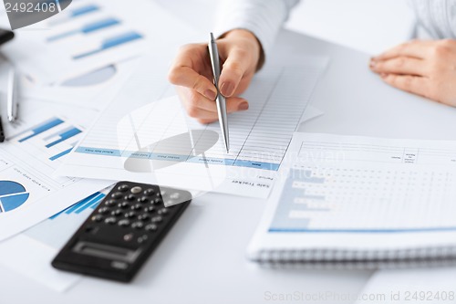 Image of woman hand with calculator and papers