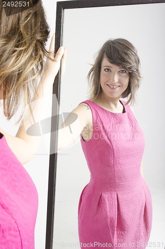 Image of real young woman looking in a mirror