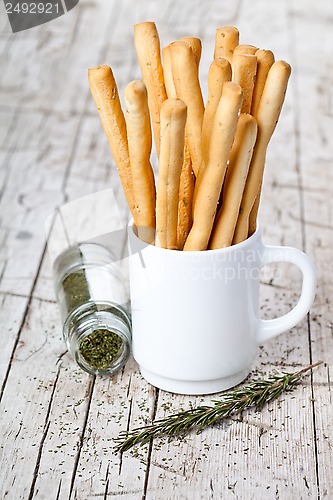 Image of cup with bread sticks grissini and rosemary