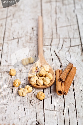 Image of hazelnuts in wooden spoon and sinnamon sticks