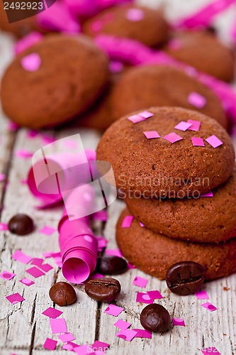 Image of fresh chocolate cookies, coffee beans, pink ribbons and confetti