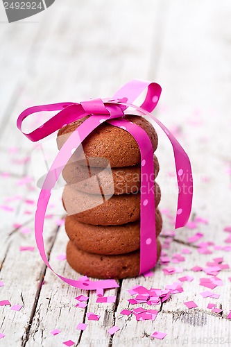 Image of chocolate cookies tied with pink ribbon and confetti 