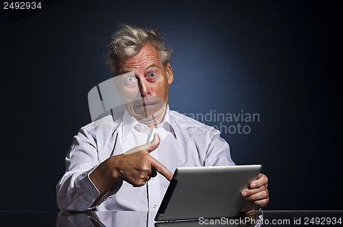 Image of Man pointing to his laptop in horror and disbelief