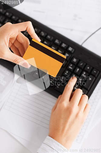 Image of businesswoman with laptop using credit card