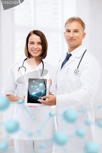 Image of two doctors showing tablet pc with molecules