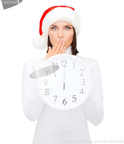 Image of woman in santa helper hat with clock showing 12