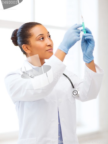 Image of african doctor holding syringe with injection