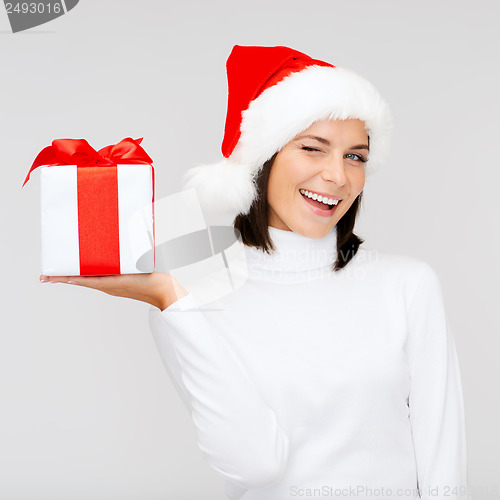 Image of smiling woman in santa helper hat with gift box