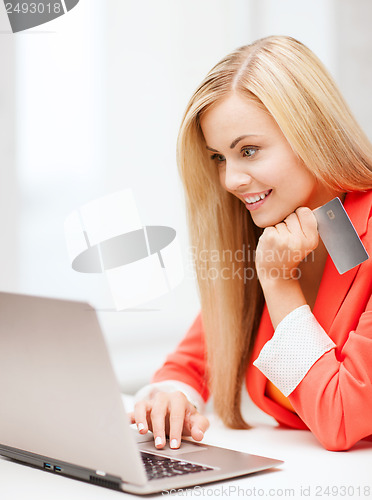 Image of businesswoman with laptop using credit card