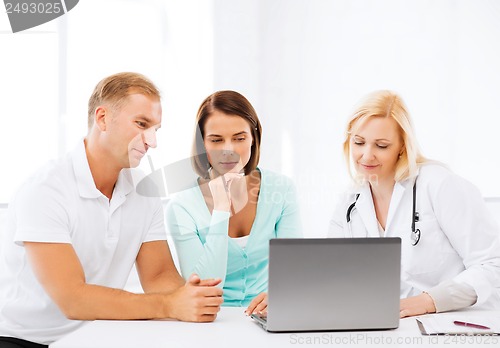Image of doctor with patients looking at laptop