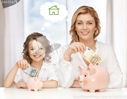 Image of mother and daughter saving money