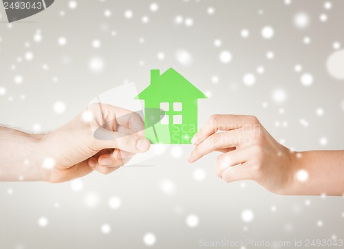 Image of couple hands holding green house