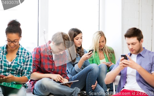 Image of students looking into devices at school