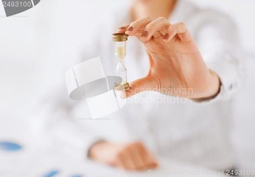 Image of woman hand with sandglass