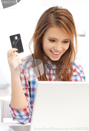 Image of happy teenage girl with laptop and credit card