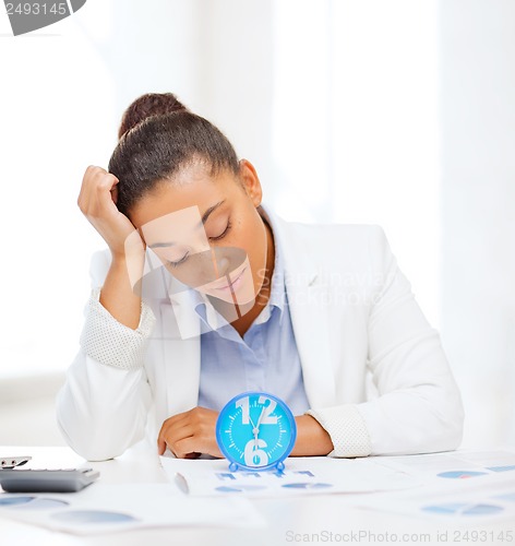 Image of businesswoman working with calculator in office