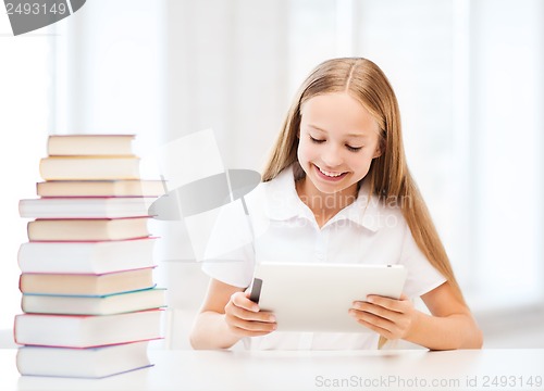 Image of girl with tablet pc and books at school