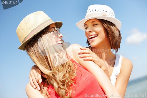 Image of girls in hats on the beach