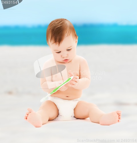 Image of little baby playing with toothbrush