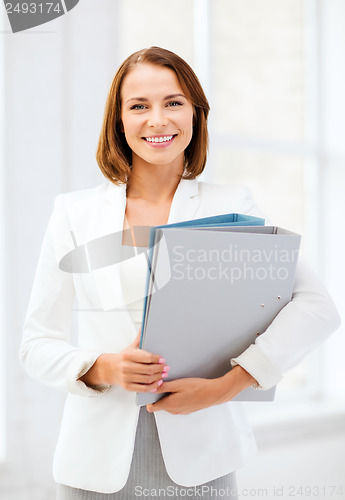 Image of businesswoman with folders in office