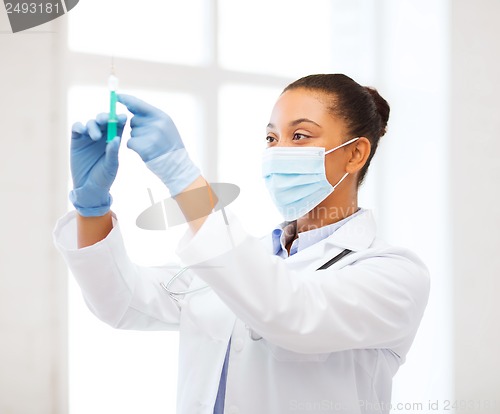 Image of african doctor holding syringe with injection