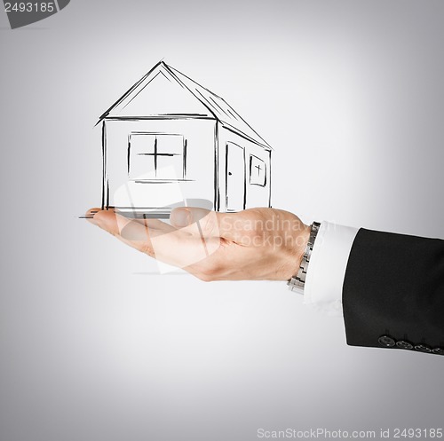 Image of house on virtual screen in man hand