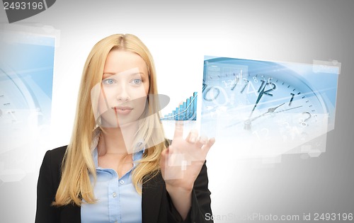 Image of businesswoman pointing at graph clock