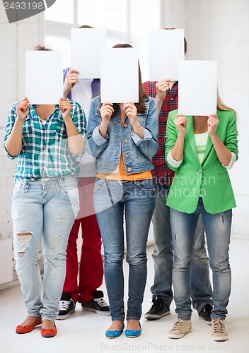 Image of students covering faces with blank papers