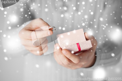 Image of man holding wedding ring and gift box