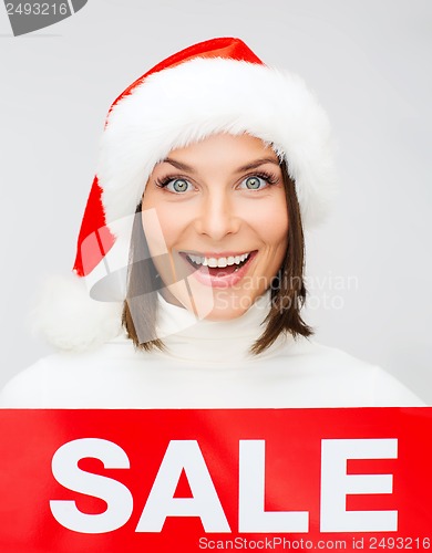 Image of woman in santa helper hat with red sale sign