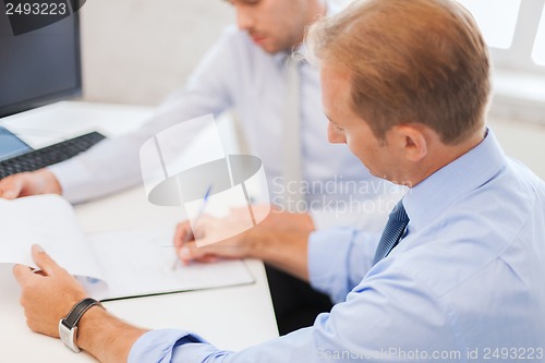 Image of businessmen with notebook on meeting