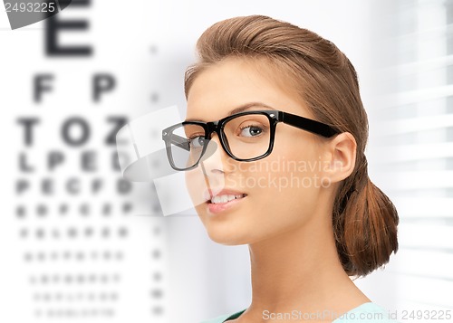 Image of woman in eyeglasses with eye chart