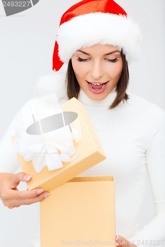 Image of surprised woman in santa helper hat with gift box