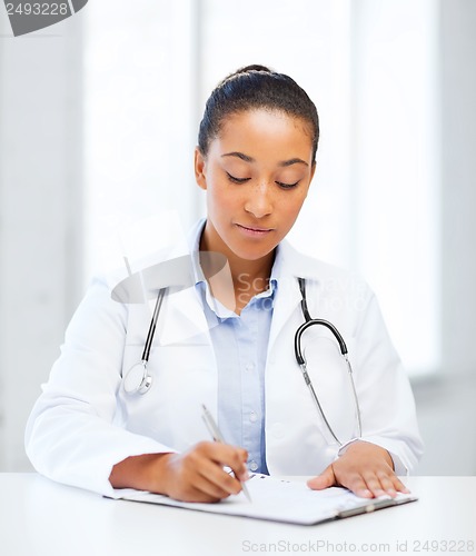 Image of female doctor writing prescription