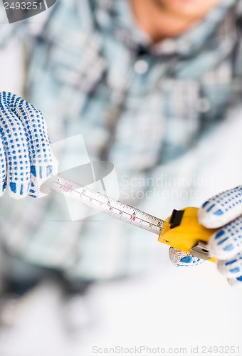 Image of architect measuring wall with flexible ruler