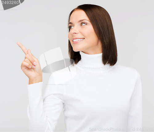 Image of woman in white sweater pointing to something