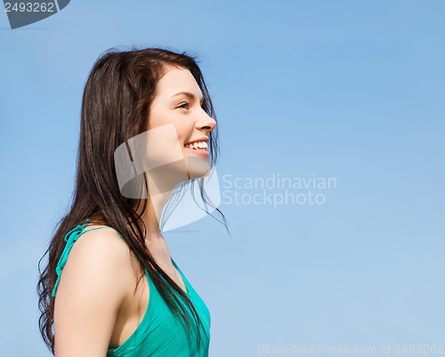 Image of beautiful girl over blue sky