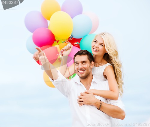 Image of couple with colorful balloons at sea side