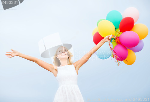 Image of woman with colorful balloons outside