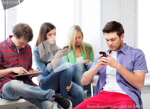 Image of students looking into devices at school