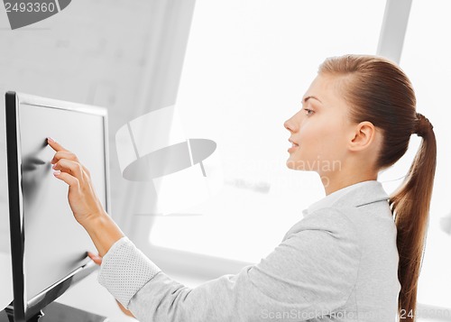 Image of smiling businesswoman with touchscreen in office