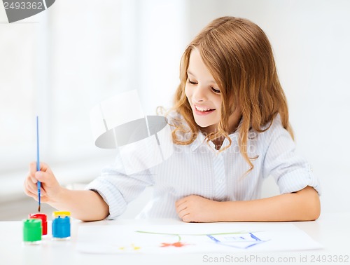 Image of little girl painting at school