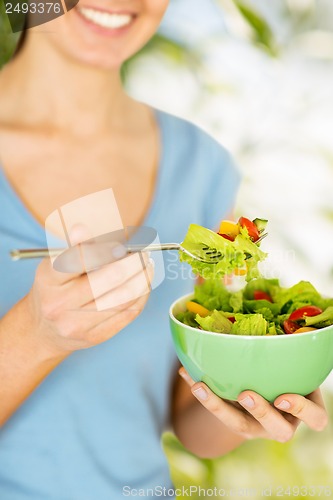 Image of woman eating salad with vegetables