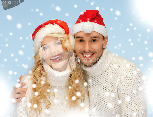 Image of family couple in sweaters and santa's hats