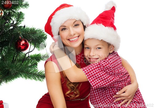 Image of happy mother and child boy in santa helper hats